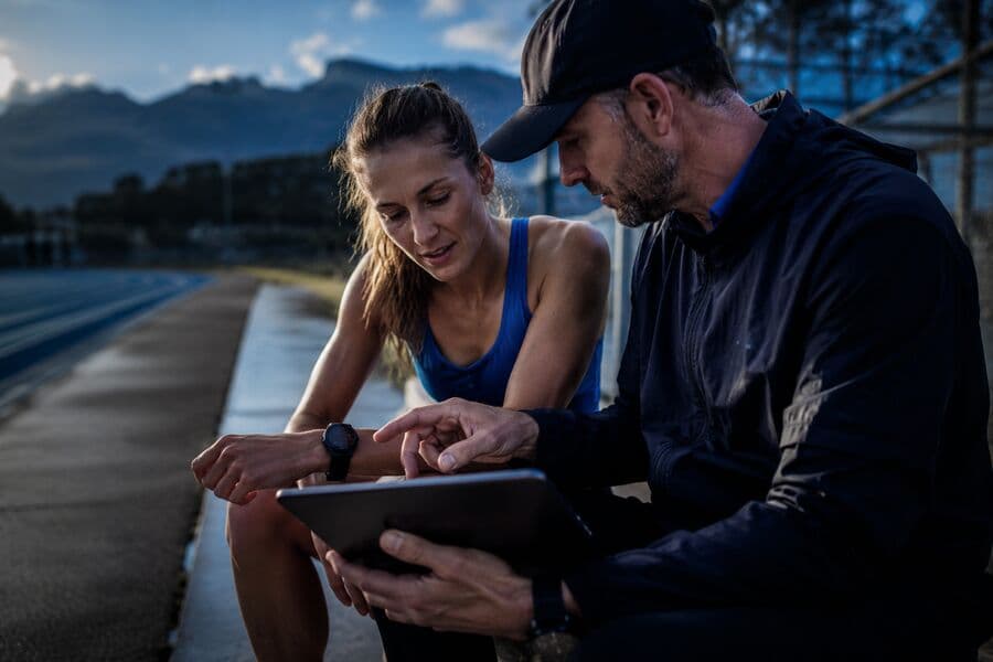 An athlete and coach reviewing results on a tablet