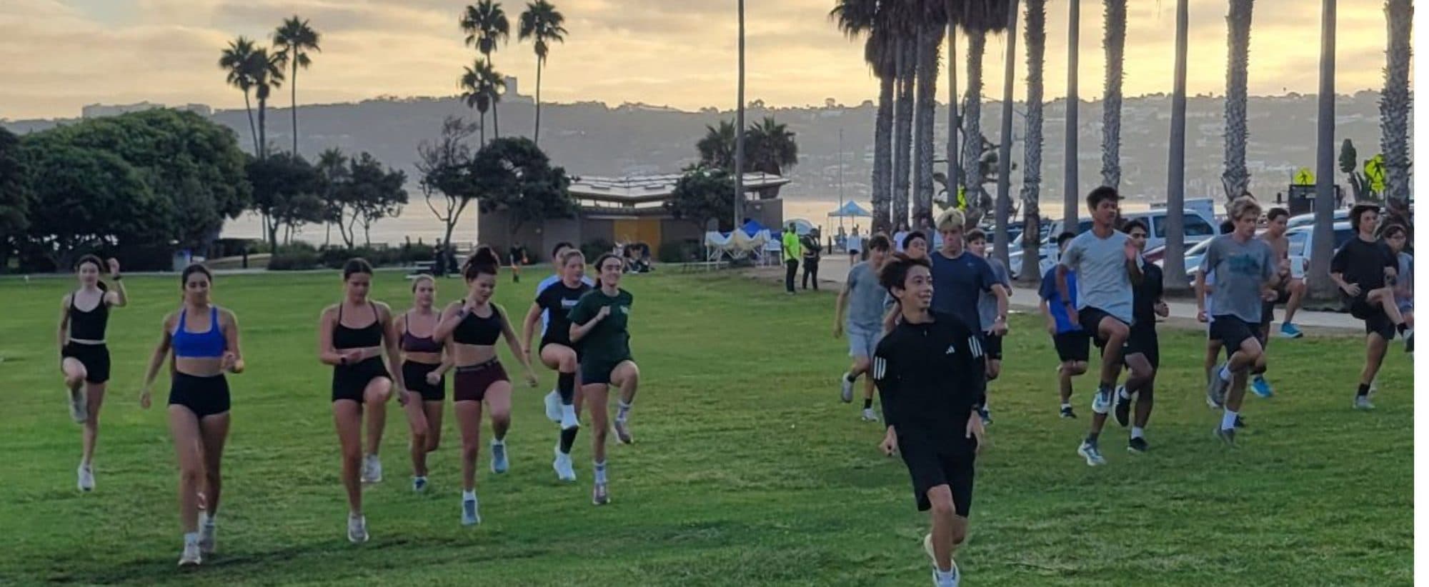 Trackbeast athletes warming up on the grass in San Diego at sunset